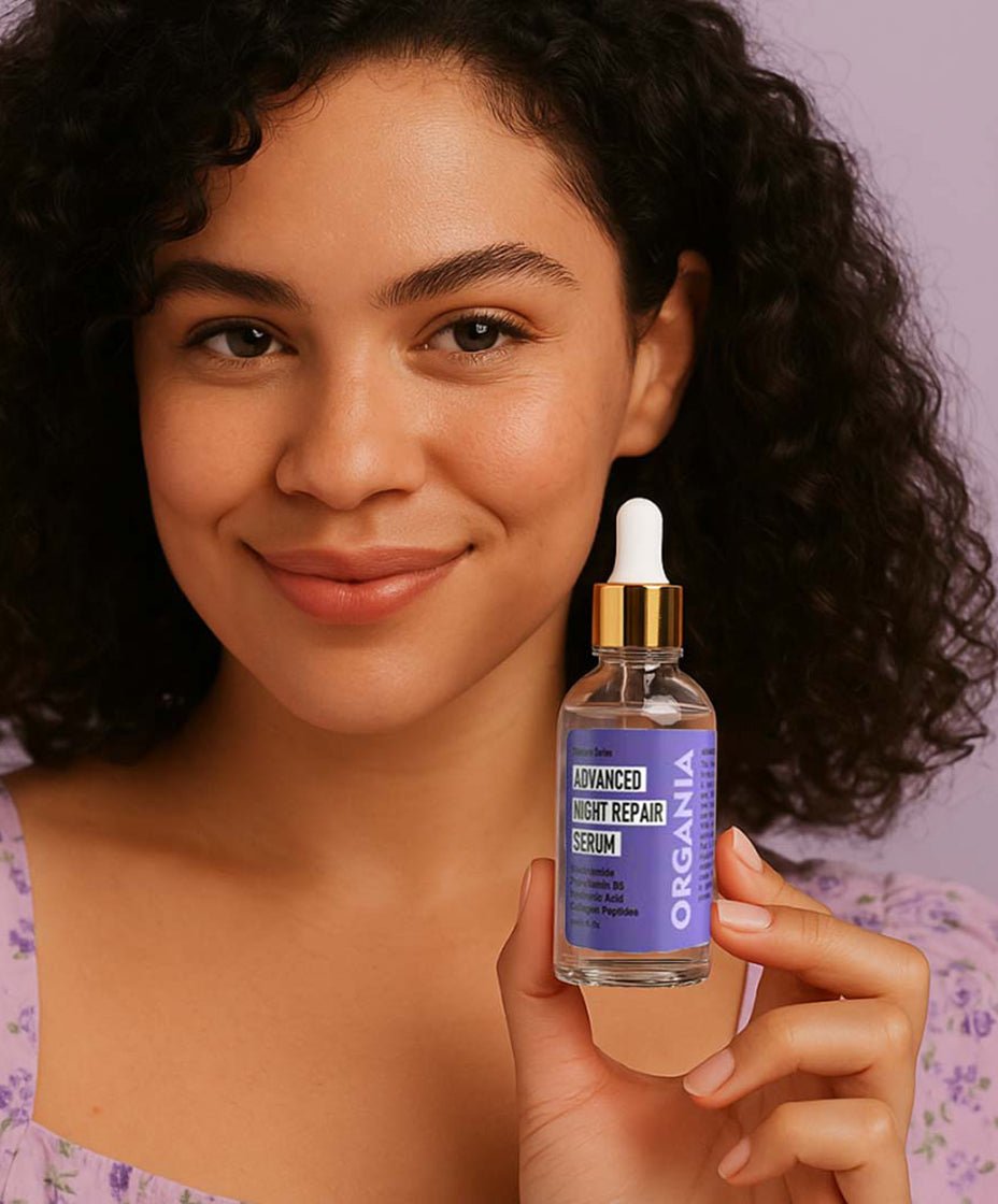Woman holding a bottle of Organia Advanced Night Repair Serum against a neutral background