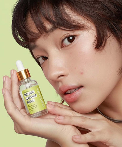 Person holding an 'Anti Acne Clarifying Serum' bottle with a green background