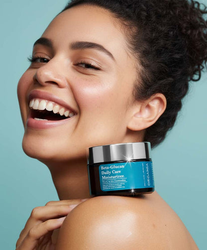 Woman holding a jar of Daily Care Moisturizer against a light blue background