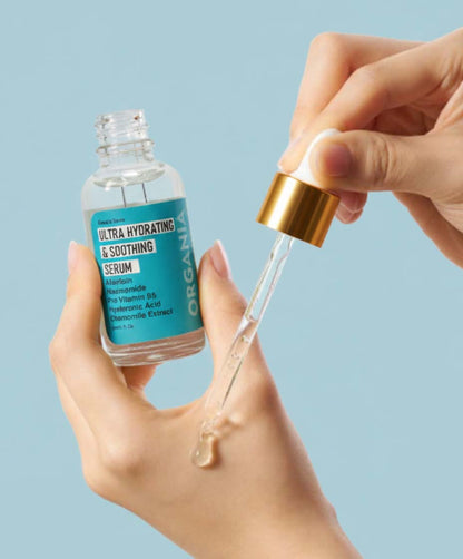 Hand holding a dropper with ultra hydrating serum against a light blue background